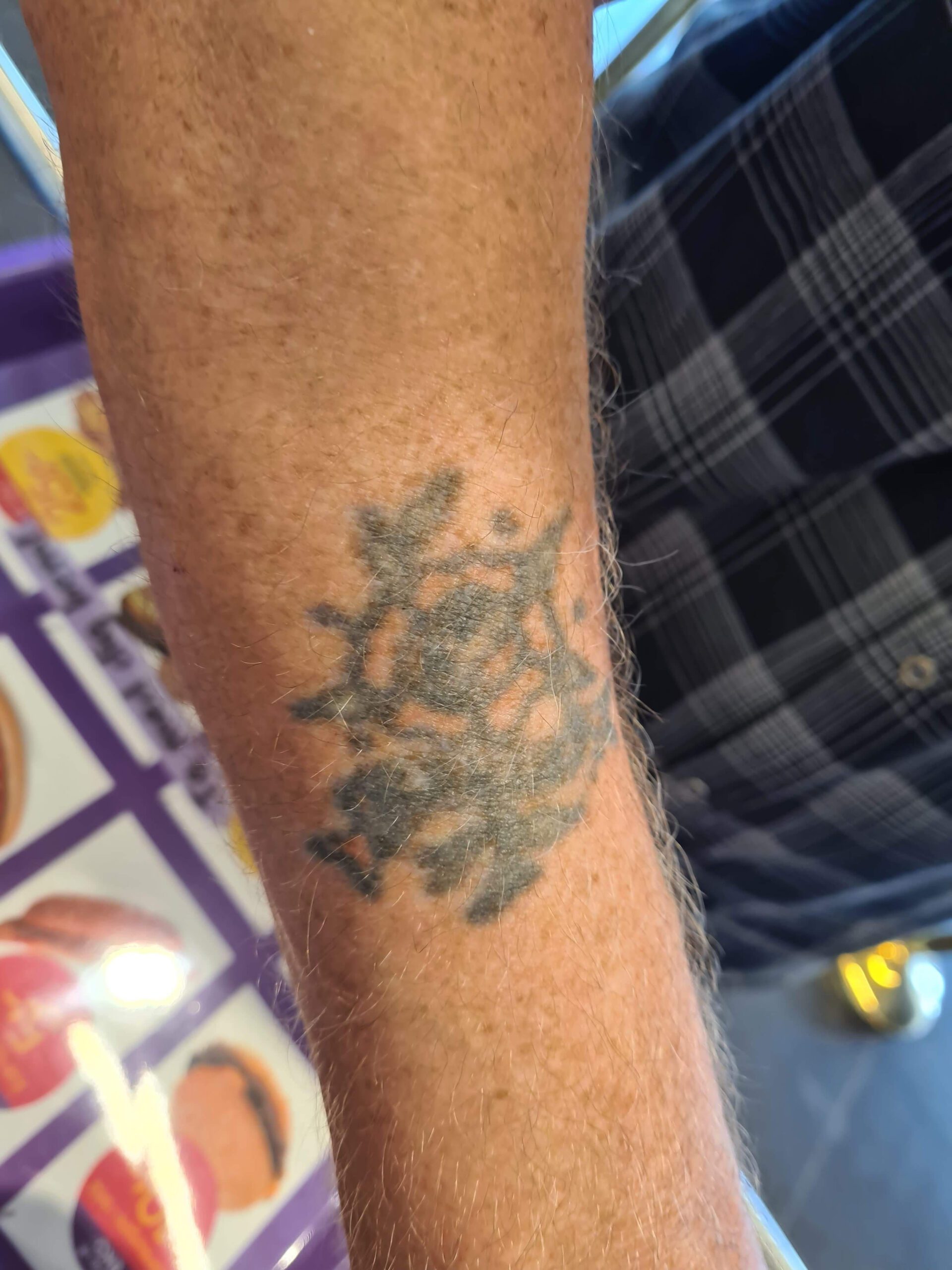 Underarmstatuering med gulröd ros med själk och blad.