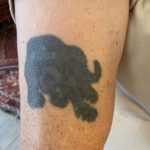 Foto av suddig äldre tatuering föreställande en krypande svart panter sedd framifrån.