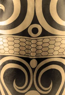 Närbild på bar rygg med japansk tribal – ett större symetriskt mönster av geometriska former, helt i svart.