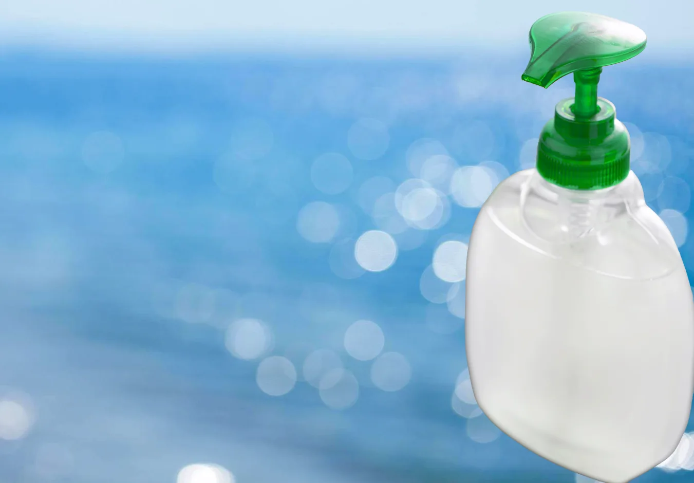 Foto pågenomskinlig, omärkt pumptvålsflaska med grönt pumphuvud. Bakgrunden utgörs av ett diffust, blåskimrande hav.